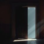 Een oude, verlaten deur in een donkere kamer met kaarslicht.